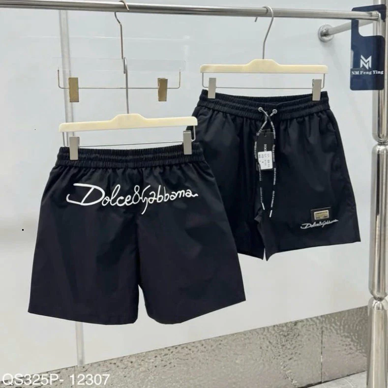 Quần short gió nam chất liệu gió dù thêu logo kim loại đùi phối chữ kí Đôn Chề sau mông lót lưới boy phố Hot Trend 2026